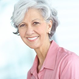 Portrait of smiling senior woman in pink blouse