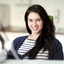 Smiling brunette woman sitting in dental chair