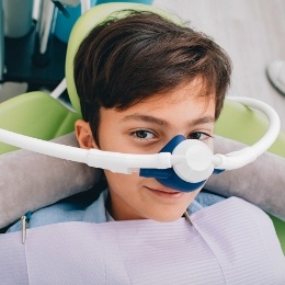 Boy in dental chair wearing nasal mask for nitrous oxide sedation