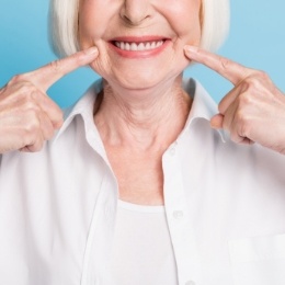 Senior woman pointing to her smile