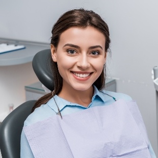 Smiling brunette woman sitting in dental chair