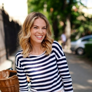 Blonde woman in striped blouse smiling after preventive dentistry in Nepean