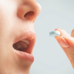 Close up of person about to take a pill